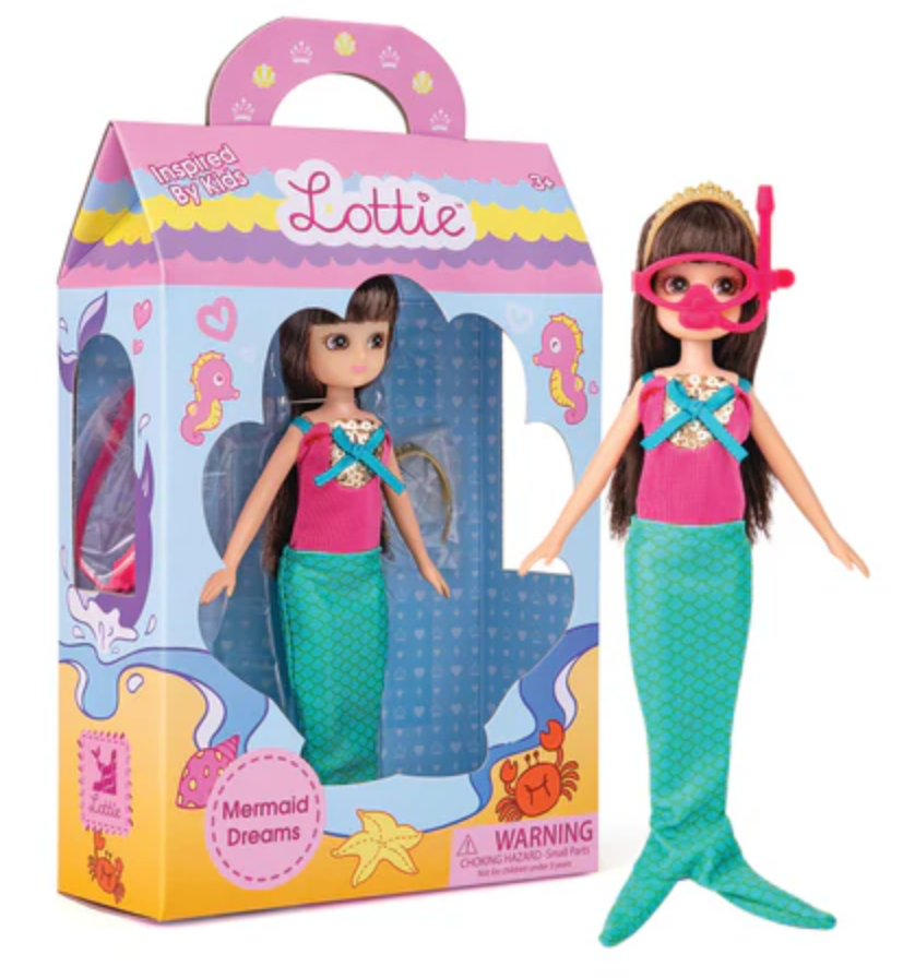 Lottie Mermaid Dreams doll with bendable knees, pink top, mermaid tail, crown, and removable diving mask in packaging.
