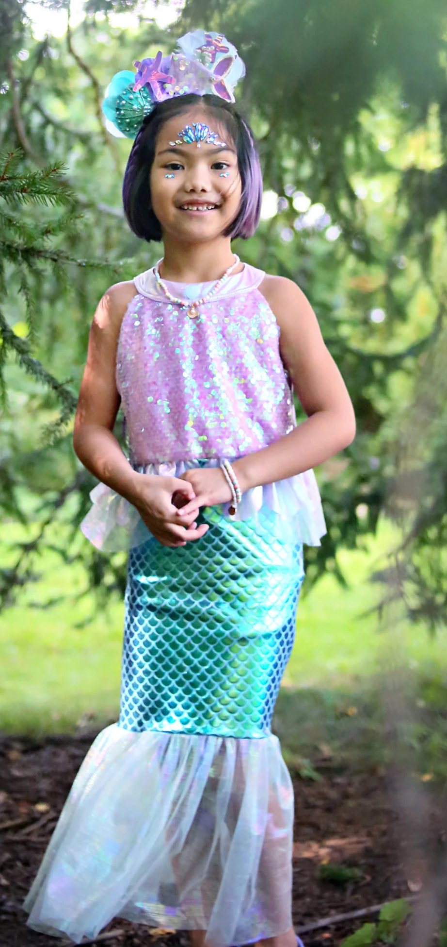 Young girl in a Misty Mermaid Dress with shimmering purple top and teal metallic scale skirt with tulle mermaid tail detail.