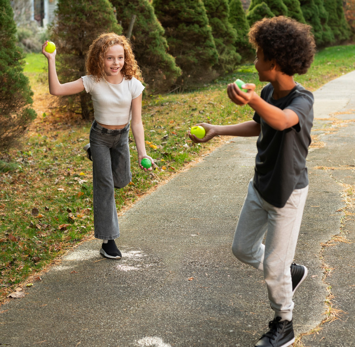 Two kids playing outside with Huckleberry Reusable Water Balloons, ready for splash-tastic summer fun.