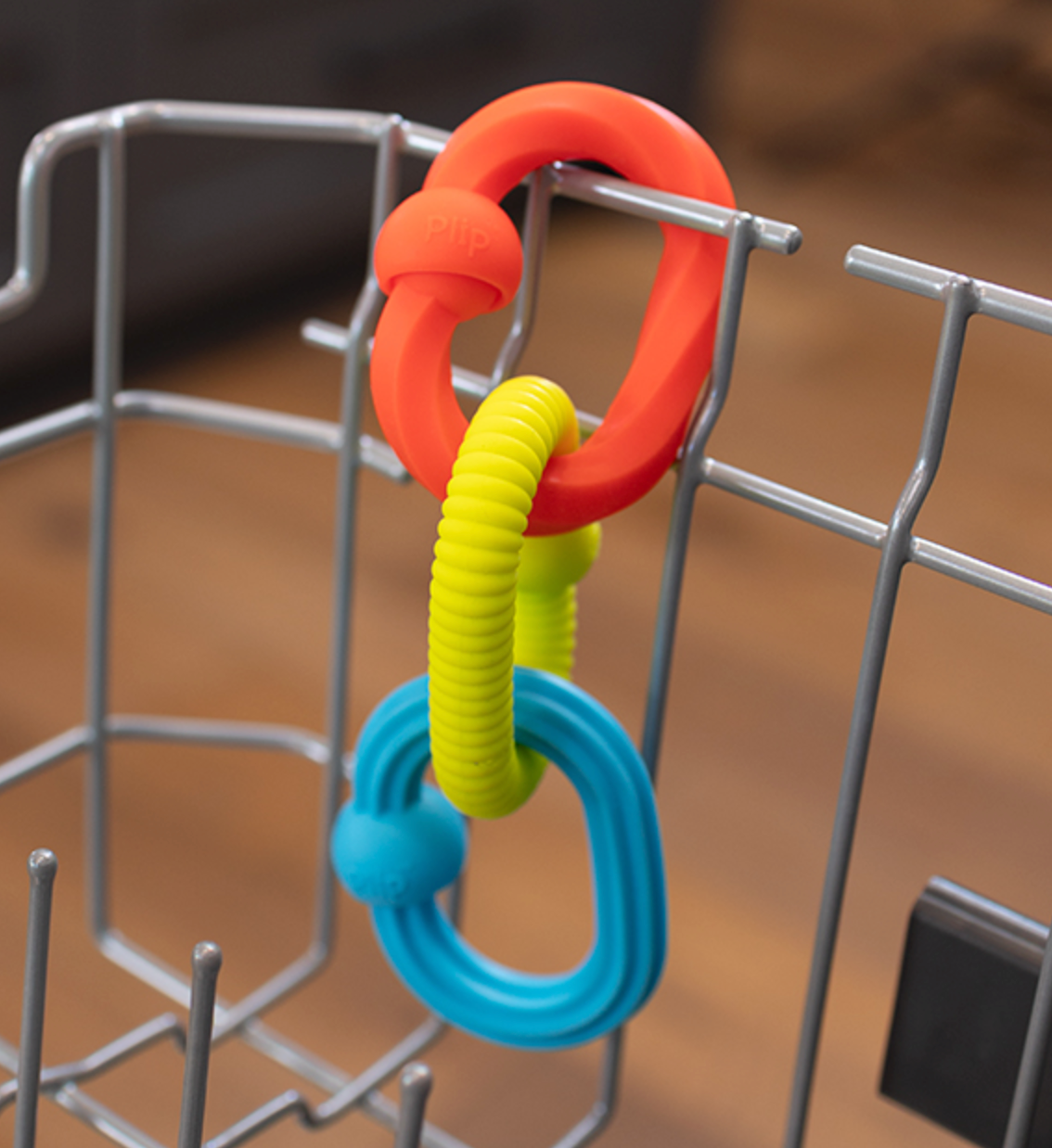 Plip Grips colorful silicone links connected and hanging, designed for sensory play and fine motor skill development.