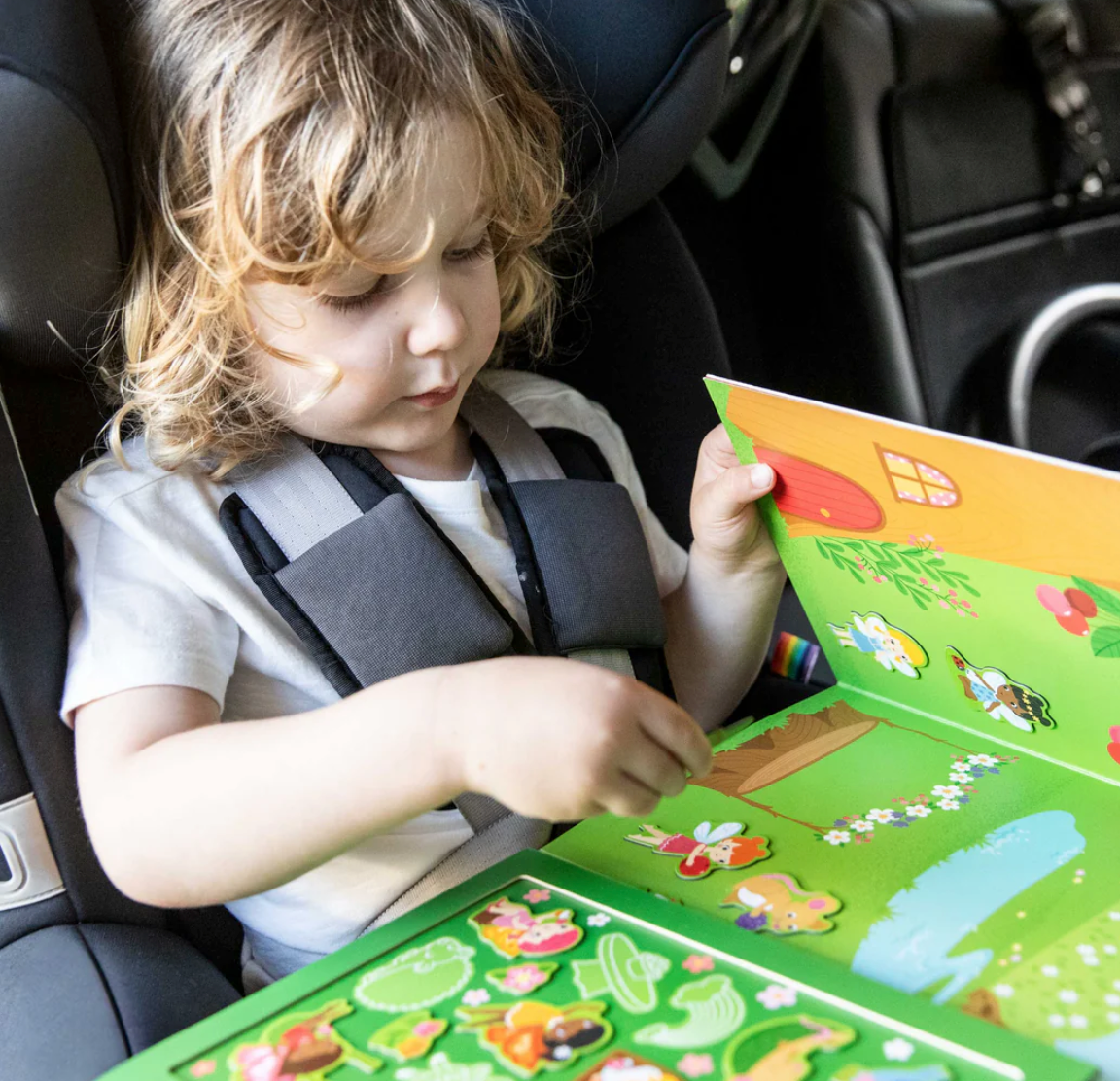 Child playing with colorful magnet pieces in the Magna Carry | Forest Fairies portable playset.