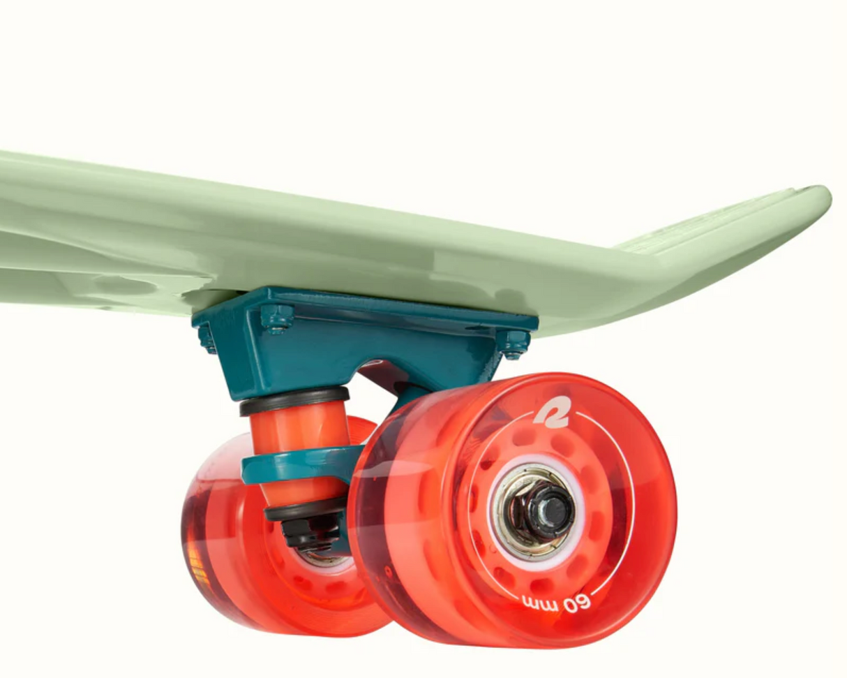 Close-up of orange wheels and green deck on the Quip Mini Cruiser Skateboard | Green Tea showing durable plastic build.