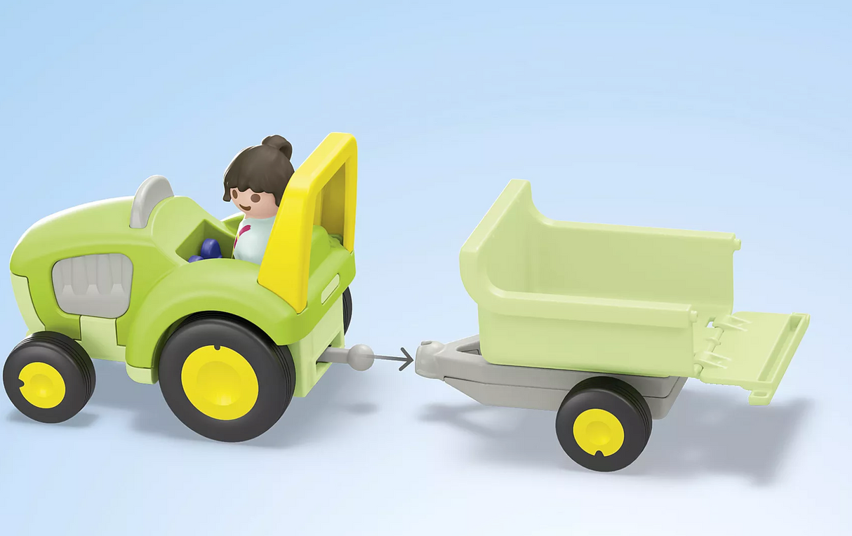 Junior | Farm Adventure with Tractor toy set featuring a child figure driving a green tractor with trailer and foldable tailgate.