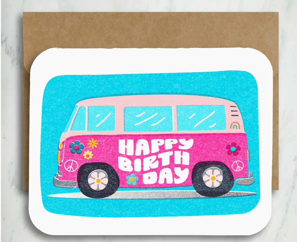 Folded birthday card featuring a pink retro bus with colorful flowers and happy birthday text on blue background