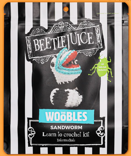 Beetlejuice-themed Sandworm crochet kit packaging with striped design and image of a coiled crocheted sandworm.