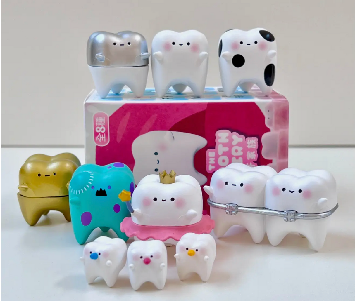 Collection of cute tooth-themed surprise figurines displayed in colorful Japanese blind box packaging