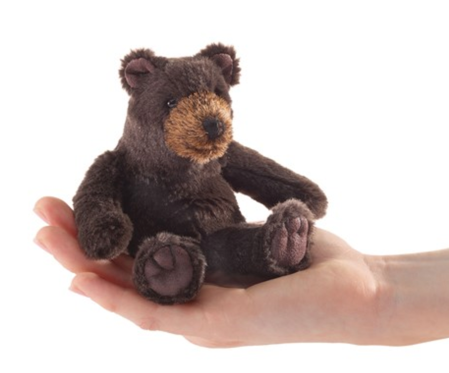 Small plush sitting bear finger puppet resting on an open hand, perfect for playful comfort and fun on the go.