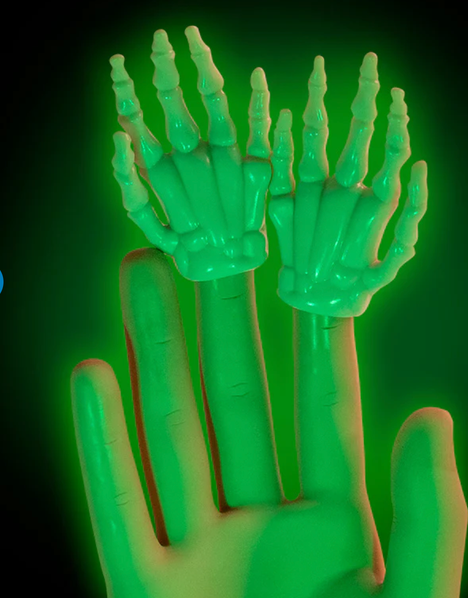 Glow in the dark small skeleton finger hands glowing bright green on fingertips over a human hand background