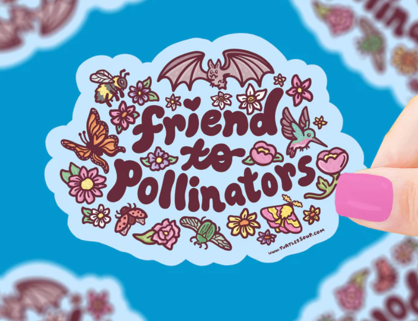 Hand holding colorful "friend to pollinators" sticker surrounded by bees, butterflies, flowers, and a bat on blue background