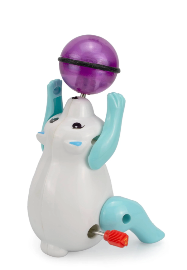 White and blue polar bear wind-up toy balancing a purple ball, designed for fun spinning action and playfulness
