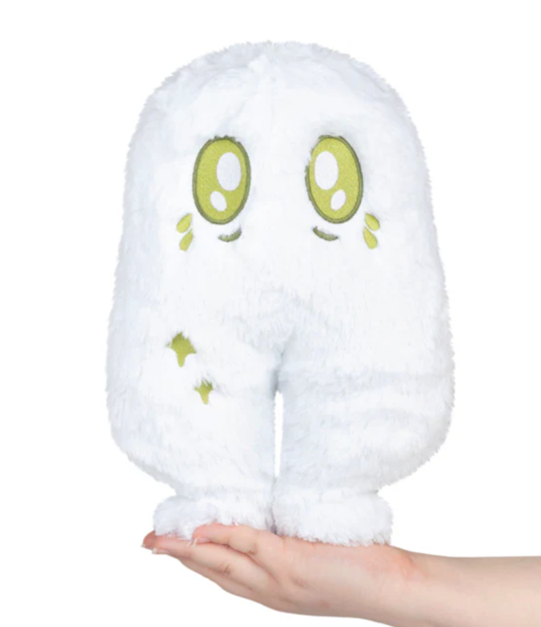 Soft white Nightcrawler Mini plush toy with green eyes sitting on an open palm against a white background