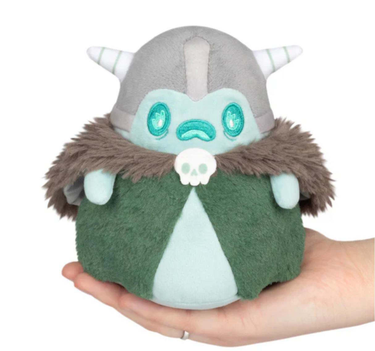Hand holding a soft plush toy of a ghost warrior with a horned helmet and green cloak with fur trim.