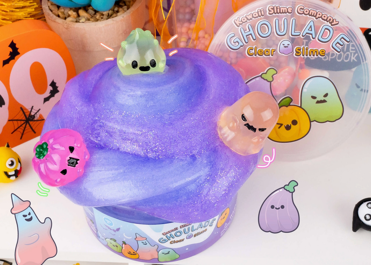 Purple glittery slime with three cute Halloween ghost charms and spooky decorations in the background