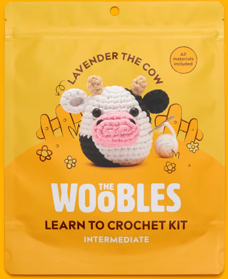 Lavender the Cow crochet kit packaging with a cute handmade crochet cow and bright yellow background