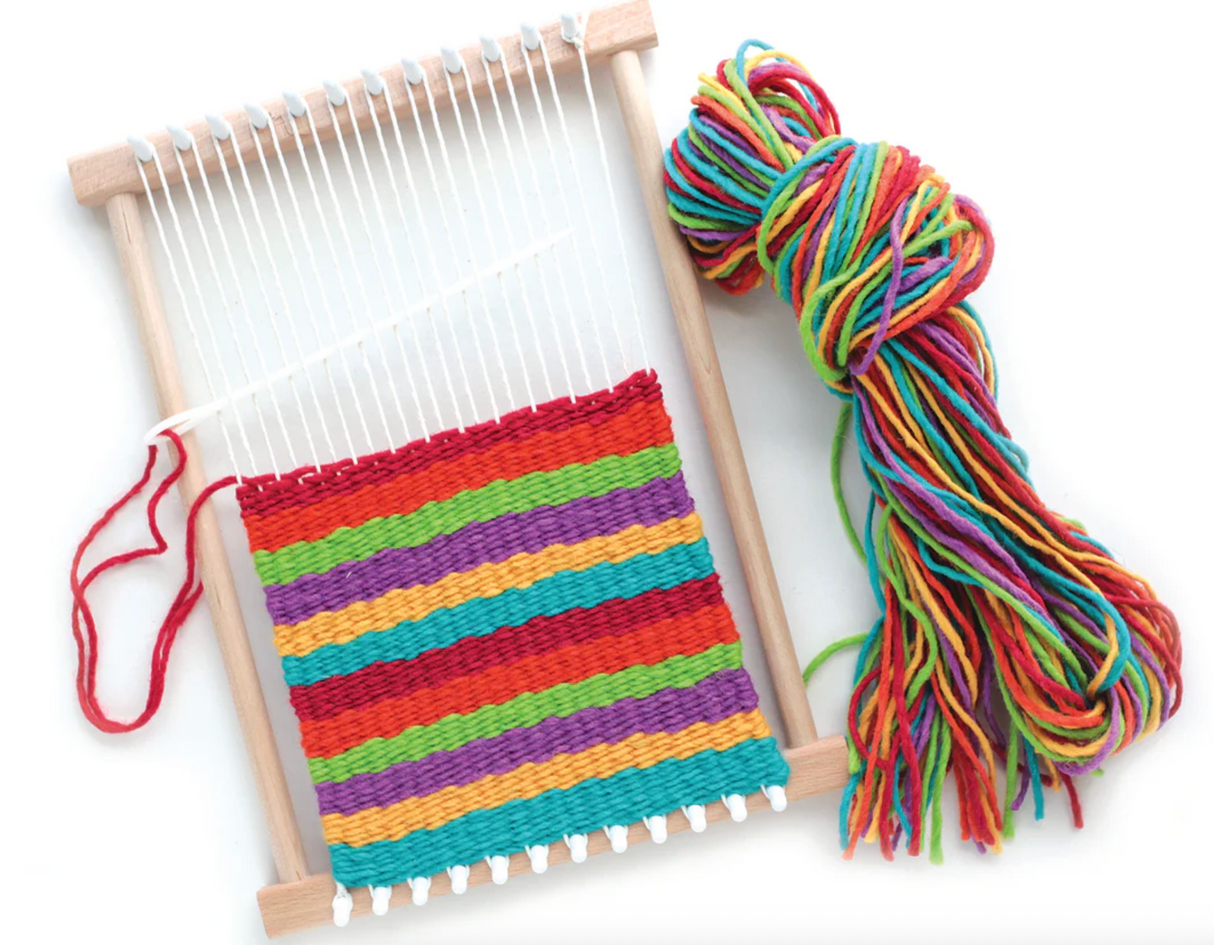 Wooden peg loom with colorful woven fabric and a bundle of multicolored yarn for weaving projects