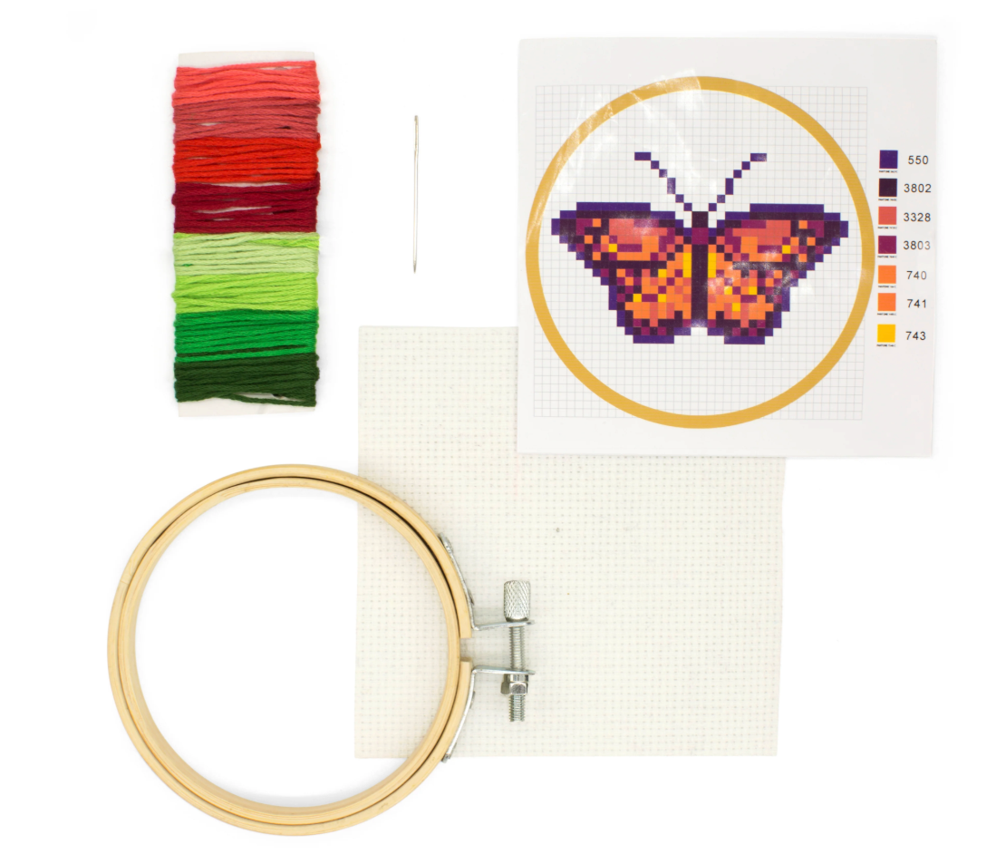 Mini butterfly embroidery kit with bamboo hoop, colorful threads, needle, canvas, and pattern guide for stitching.