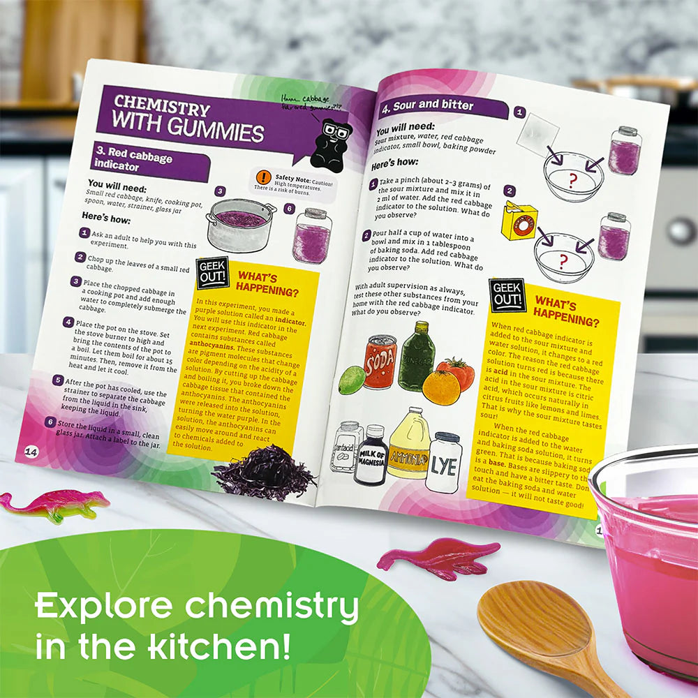 Dinosaur Gummy Candy Lab showing an open chemistry guide with dino gummies, mixing bowl, and wooden spoon on table.