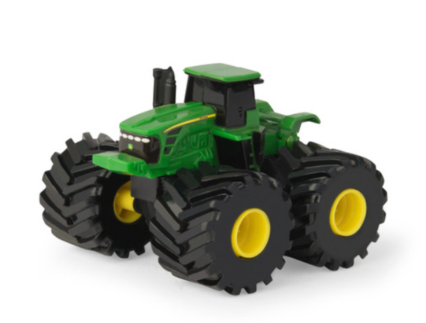 Green toy tractor with oversized black and yellow tires designed for rugged play on various surfaces