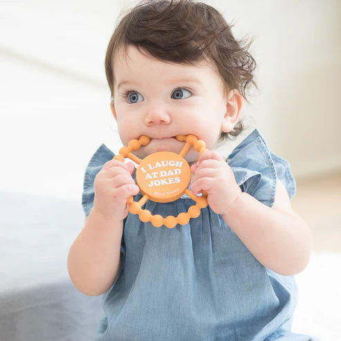 Baby chewing on silicone teether I Laugh at Dad Jokes designed for teething relief and sensory stimulation.