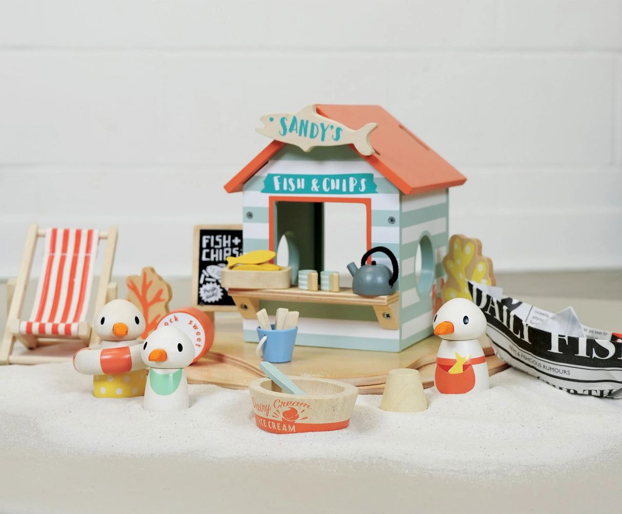 Sandy's Beach Hut wooden toy set with seagulls, fish and chips stall, deck chair, and seaside accessories for imaginative play.