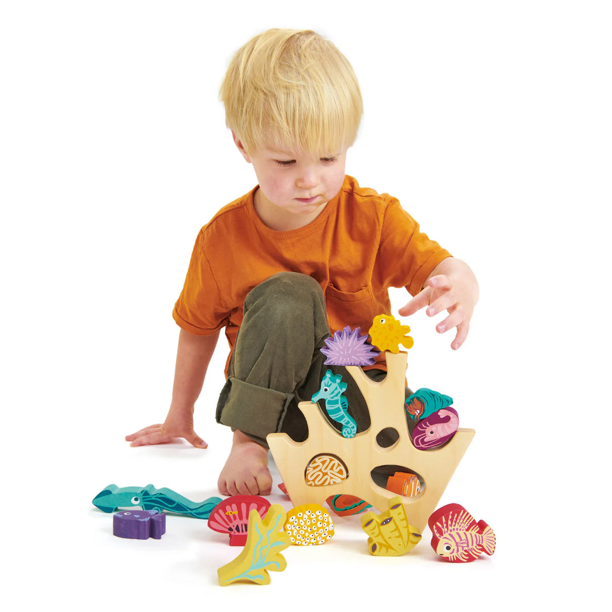 Child playing with colorful wooden sea creatures in the Stacking Coral Reef educational toy set.