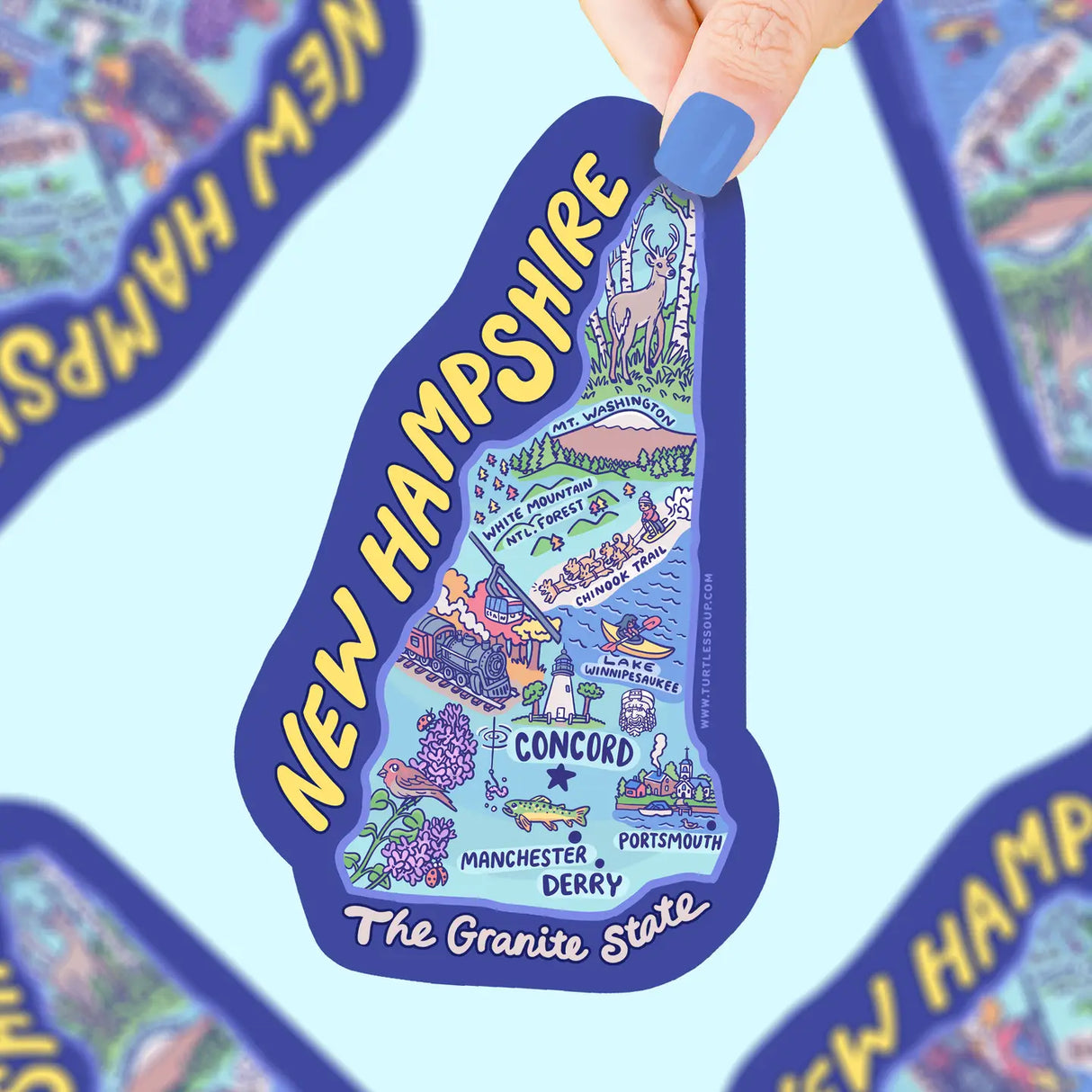 Hand holding a colorful New Hampshire map sticker featuring landmarks and cities on durable vinyl material