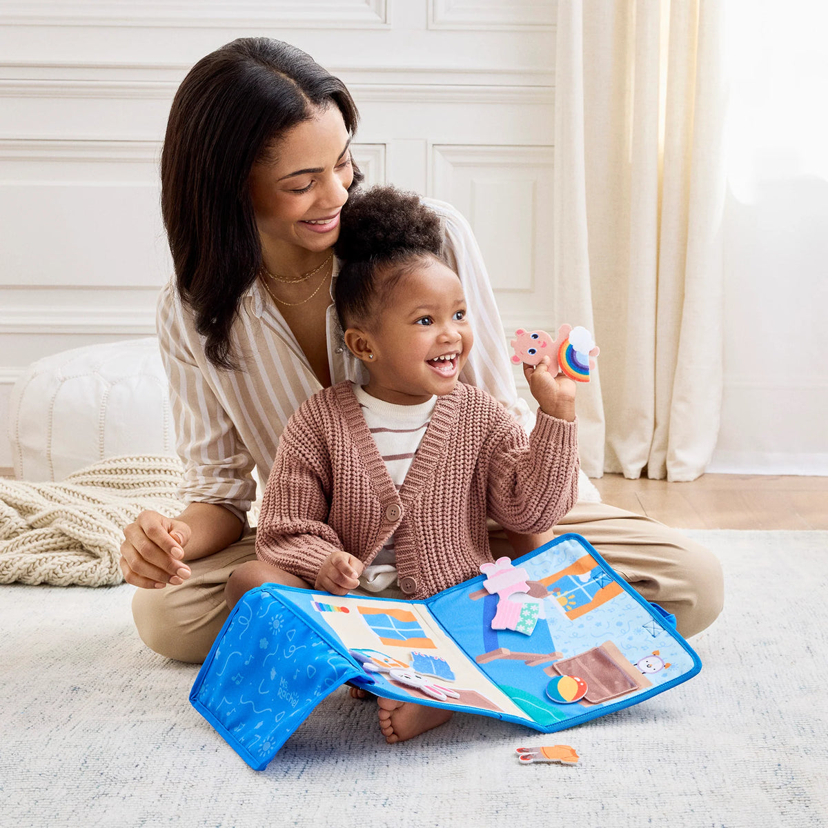 Ms Rachel What to Wear Felt Activity with child and parent exploring a colorful felt activity book