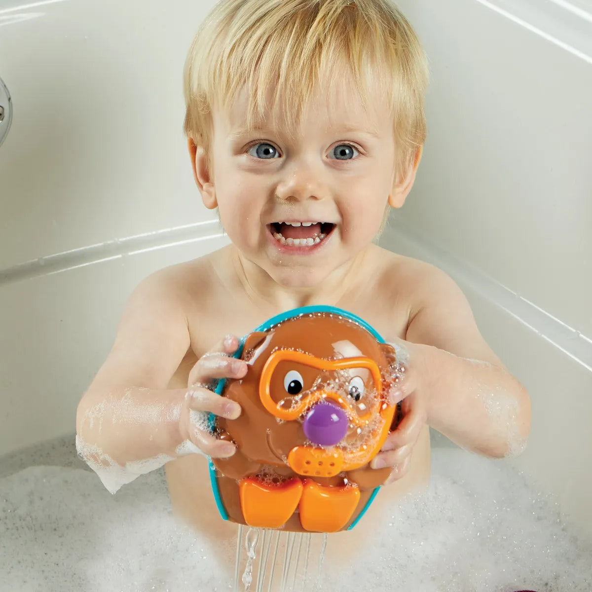 Child happily playing with Spike Hedgehog Splashin Friend bath toy in bubbly water during bath time.