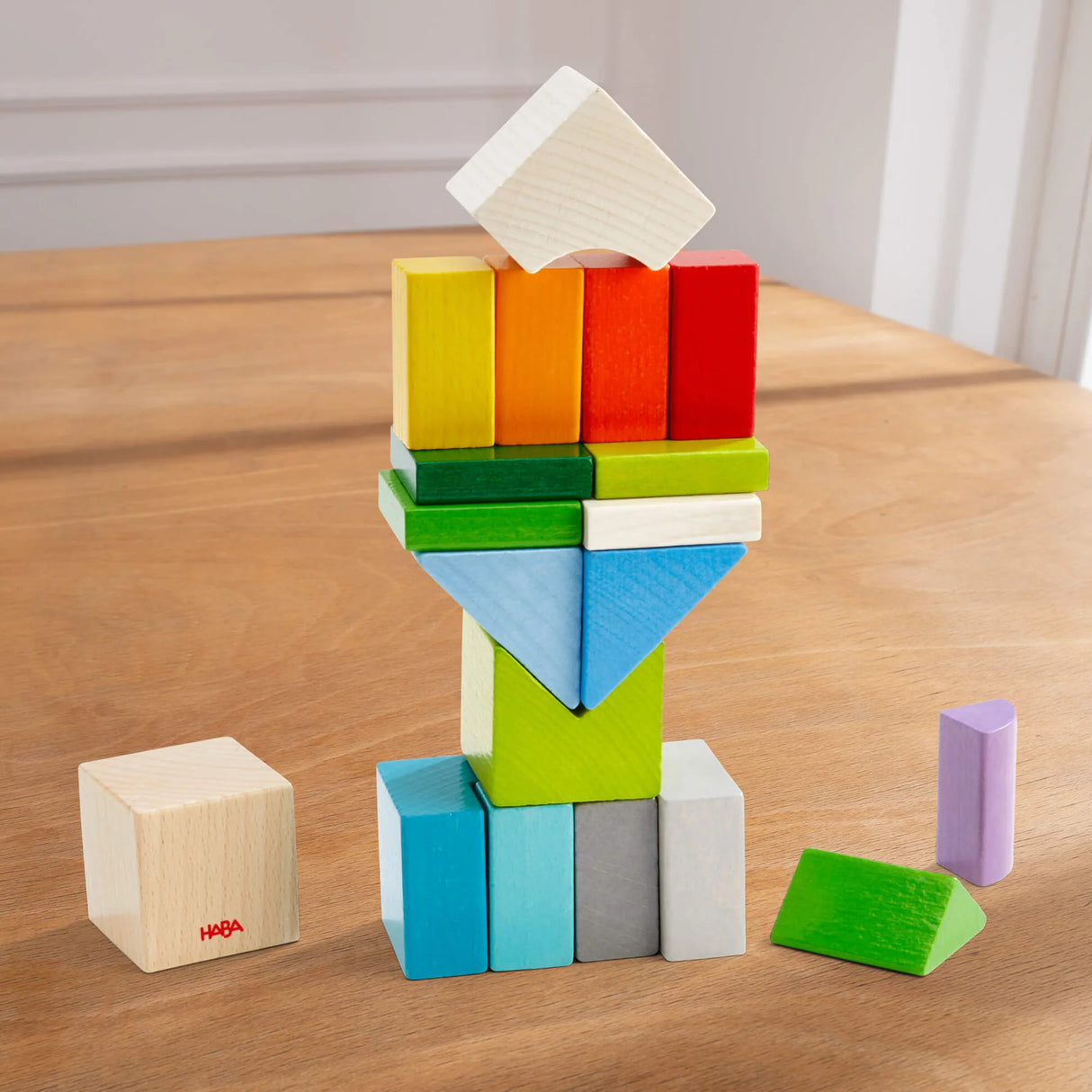 Colorful wooden blocks stacked creatively forming a unique shape on a wooden surface for playful arrangement.
