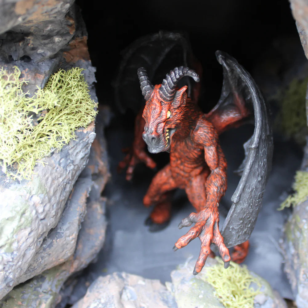 Jersey Devil figurine with bat wings, horns, and clawed hands standing in a rocky cave setting, detailed collectible.