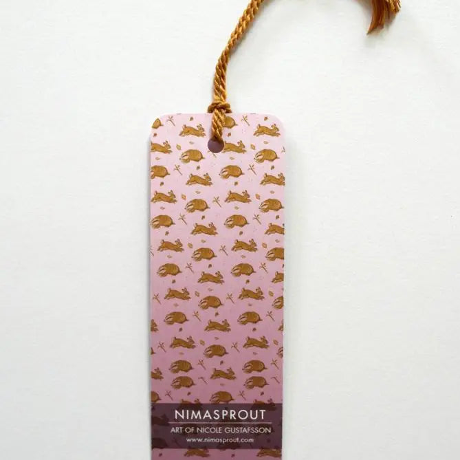 Bookmark Berry Harvesters with bronze tassel, illustrated badger and rabbit pattern on back, 5.5 x 2 inches.