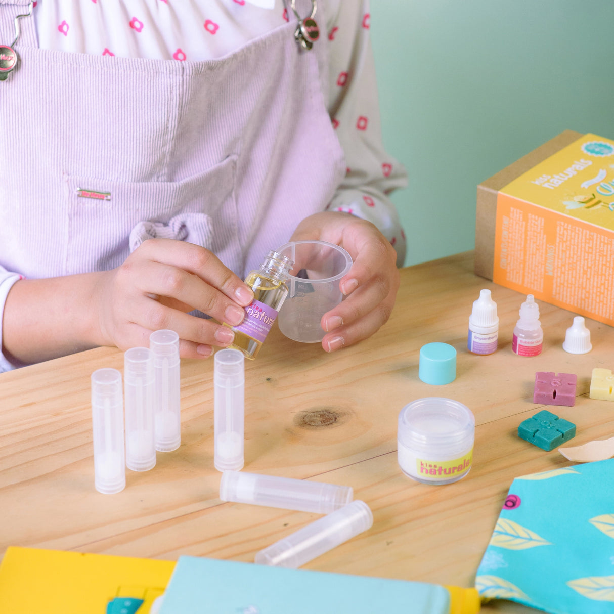 Child making lip balms with the DIY Lip Balm Kit using natural ingredients and customizable fragrances.