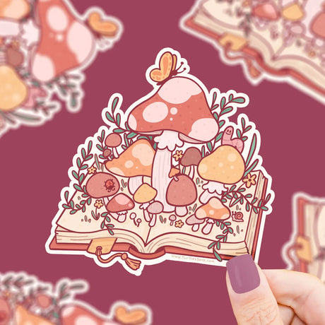 Mushroom Book Sticker showing colorful mushrooms growing from an open book held against a maroon background