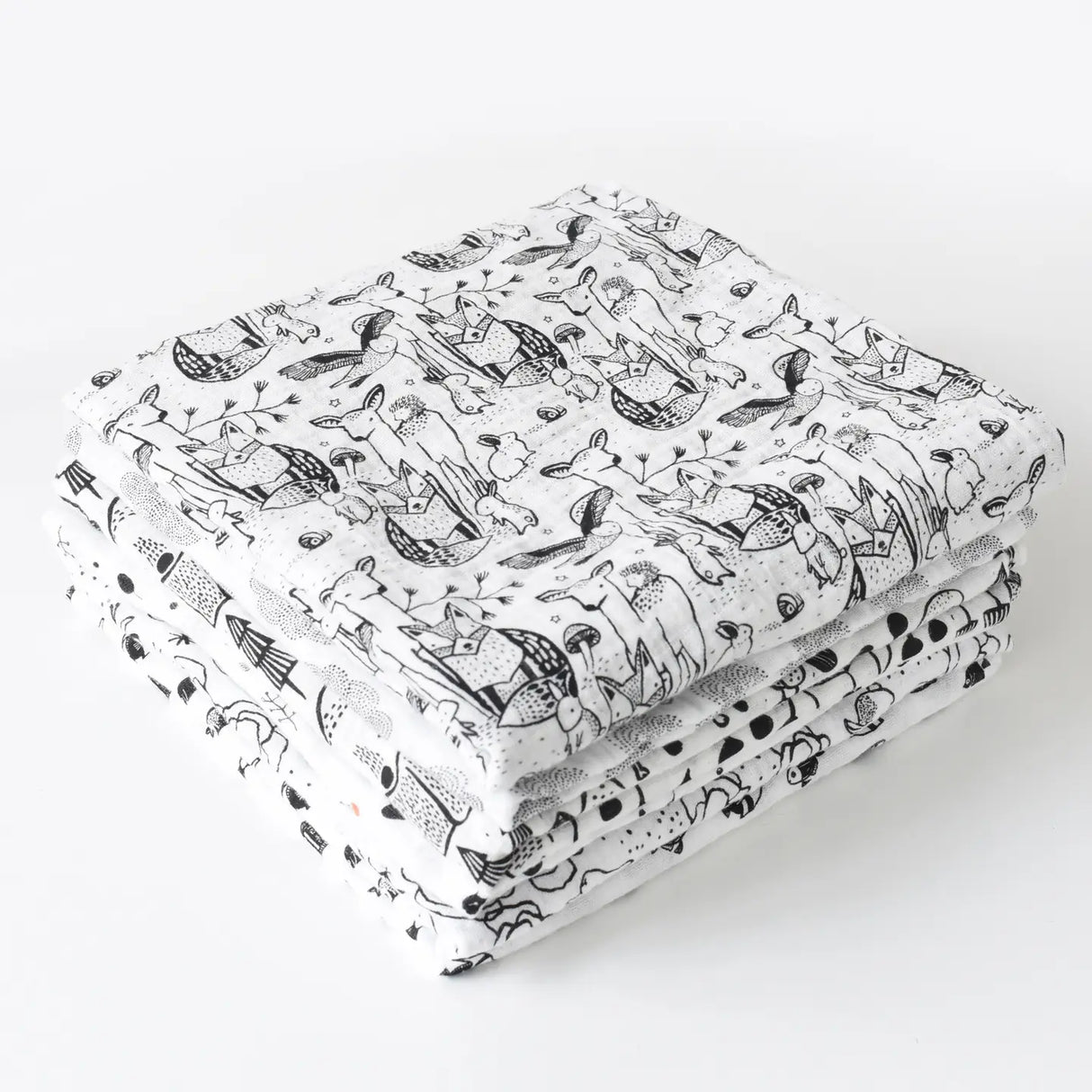 Stack of Organic Muslin Swaddle | Forest featuring black and white animal prints made from 100% organic cotton muslin.