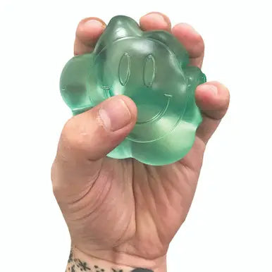 Hand squeezing translucent green Super Duper Sugar Squisher | Daisy with a smiling face design.