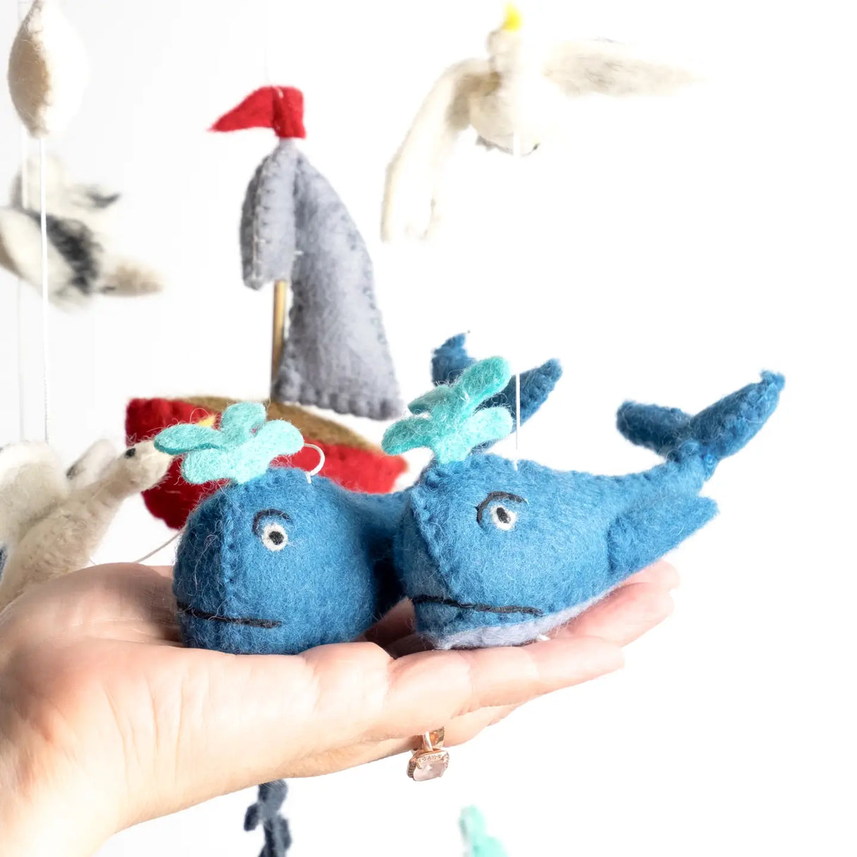 Felt Mobile | Whale & Sailboat showing handmade blue whales and sailboat from natural wool nursery decor mobile.