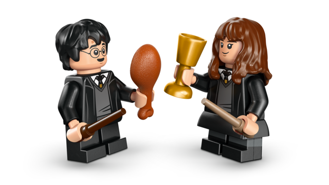 LEGO minifigures of a boy and girl in wizard robes holding a wand, drumstick, and golden goblet facing each other