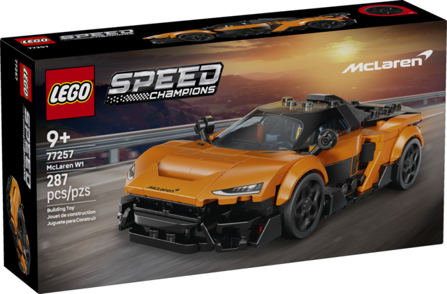 Orange race car model with detailed design and a mini driver figure in racing gear on a racetrack background