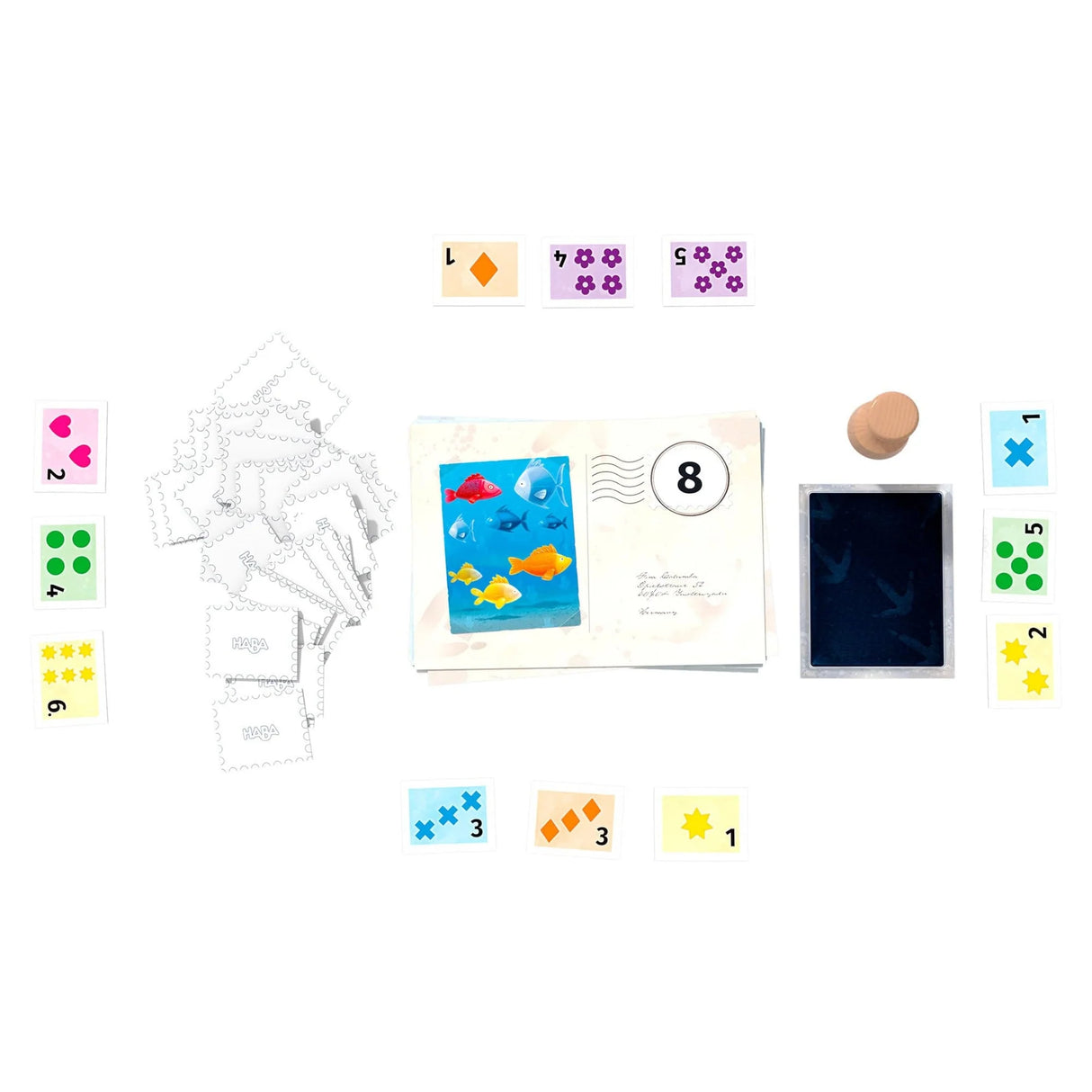 Colorful game pieces including postage stamp tiles and postcards for a children’s math learning game.