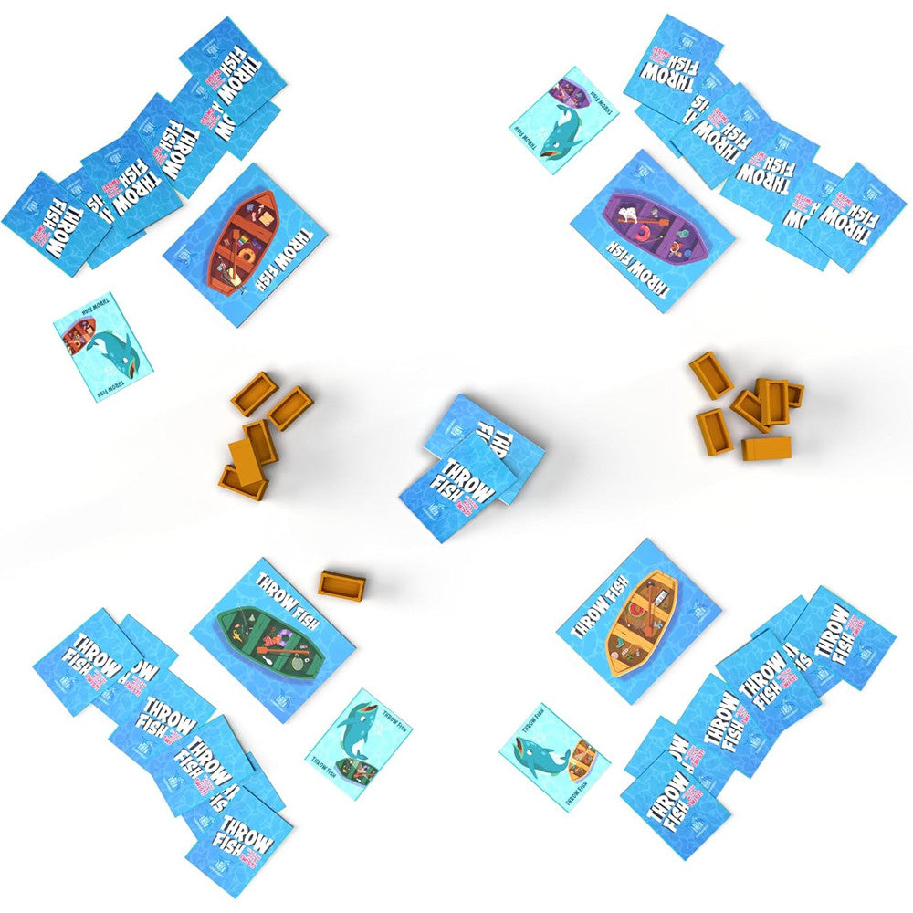Throw Fish card game setup with colorful fish cards and boat tokens ready for play on a white surface.