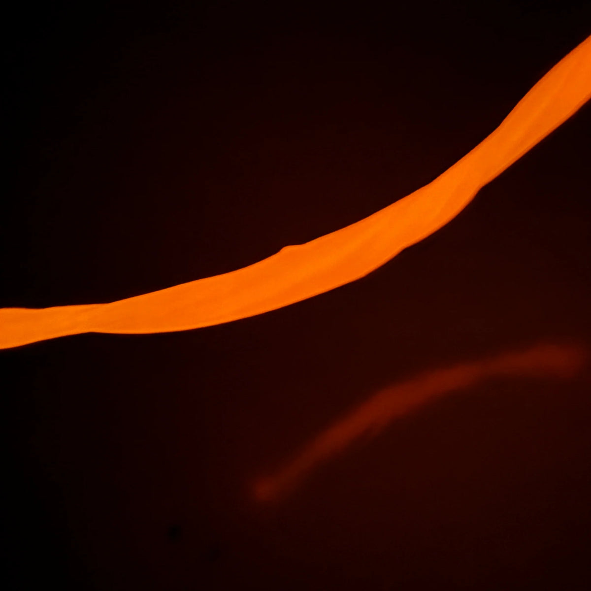 Gootonium: Glowing Orange Solar Putty stretched into a bright glowing strand