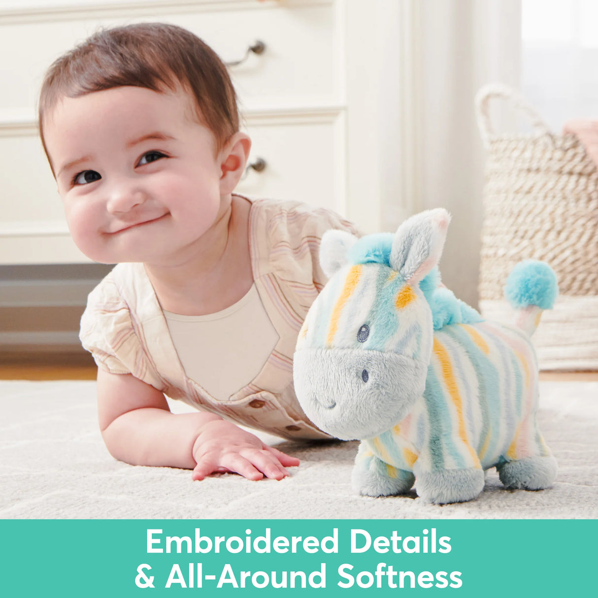 Baby playing with soft, squeezable Safari Friend Zebra plush toy with embroidered details and gentle rattle sound.