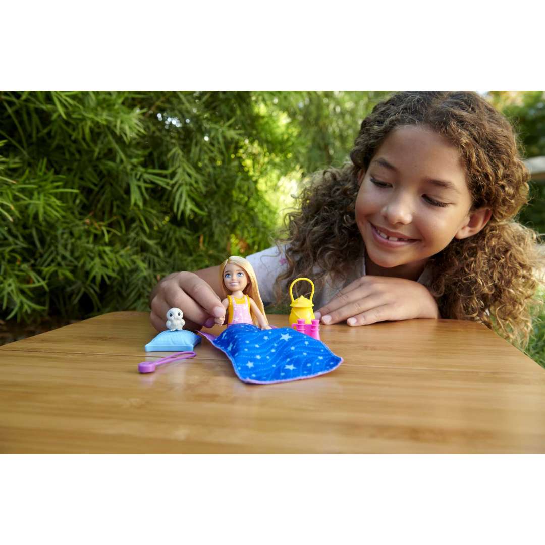 Girl playing with Barbie Chelsea Camping doll and accessories including sleeping bag, lantern, and baby owl toy.