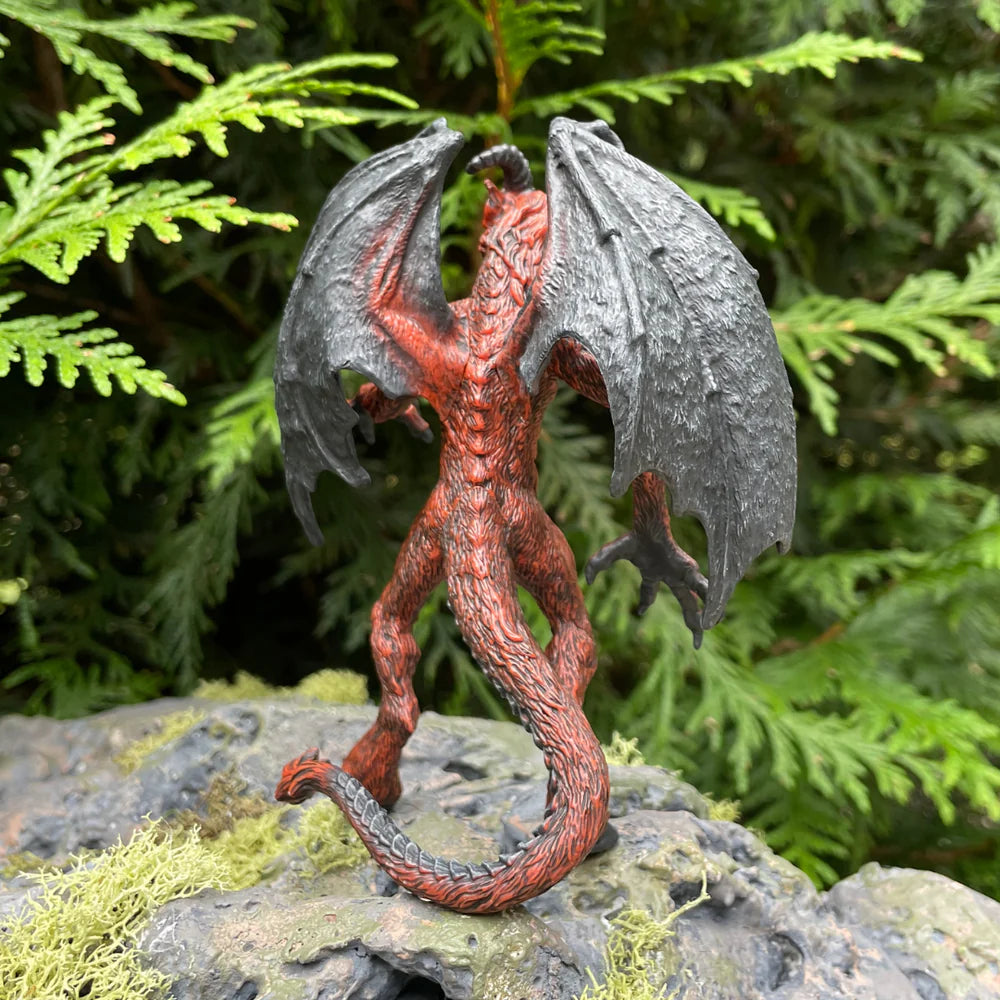 Jersey Devil figure with detailed bat-like wings, cloven hooves, and goat-like horns standing on a rock outdoors.