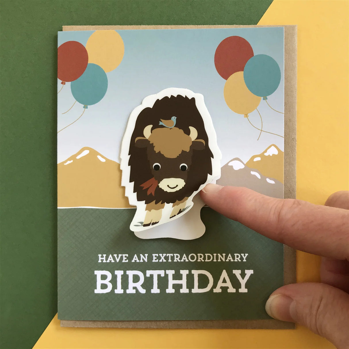 Bison Sticker Birthday Card with peel-off bison sticker on a folded card featuring balloons and mountains background.