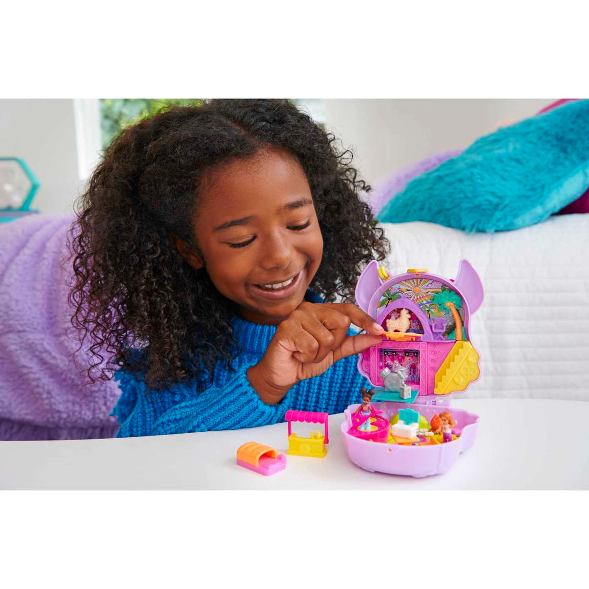 Girl playing with Polly Pocket Camp Adventure Llama Compact featuring micro dolls and colorful playset accessories.