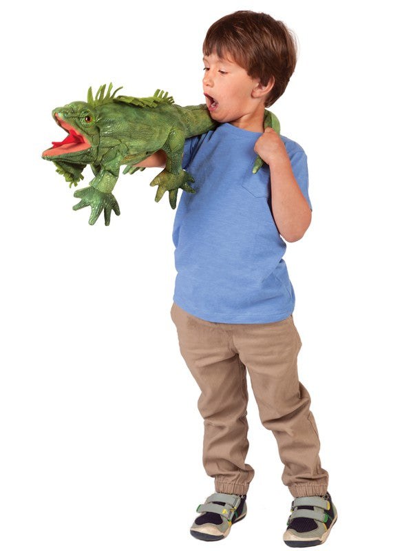 Child playing with a green Iguana Puppet featuring movable tongue, jaws, and feet in a friendly pose.