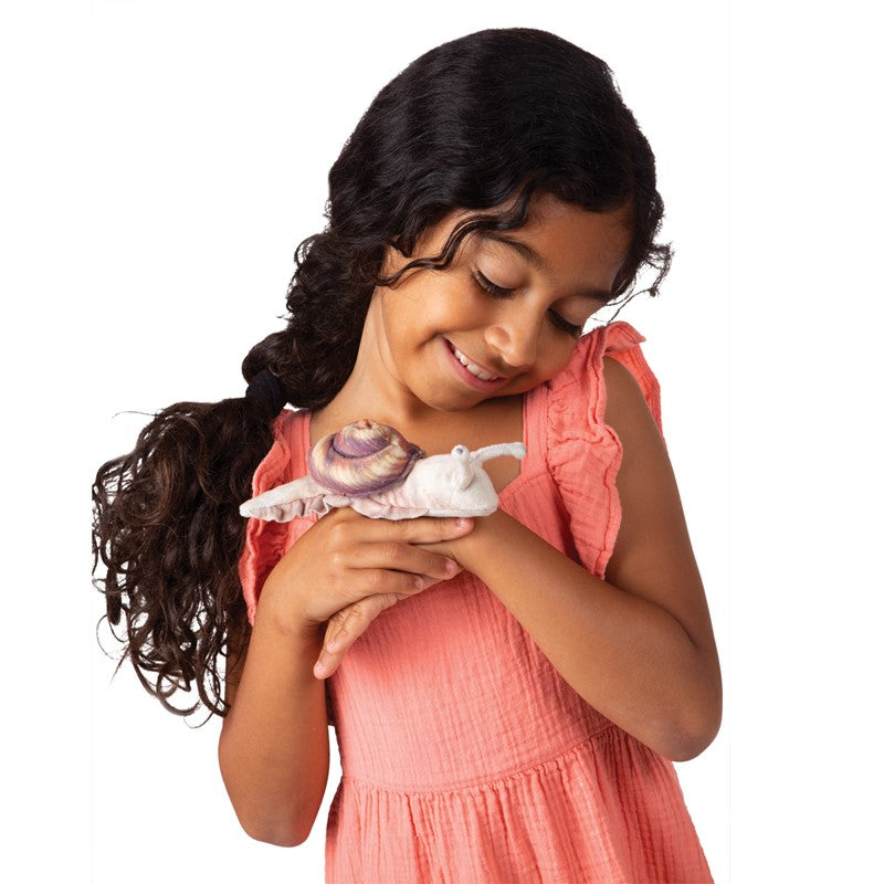 Girl smiling while holding a Snail Finger Puppet on her hand for storytelling and nature play.