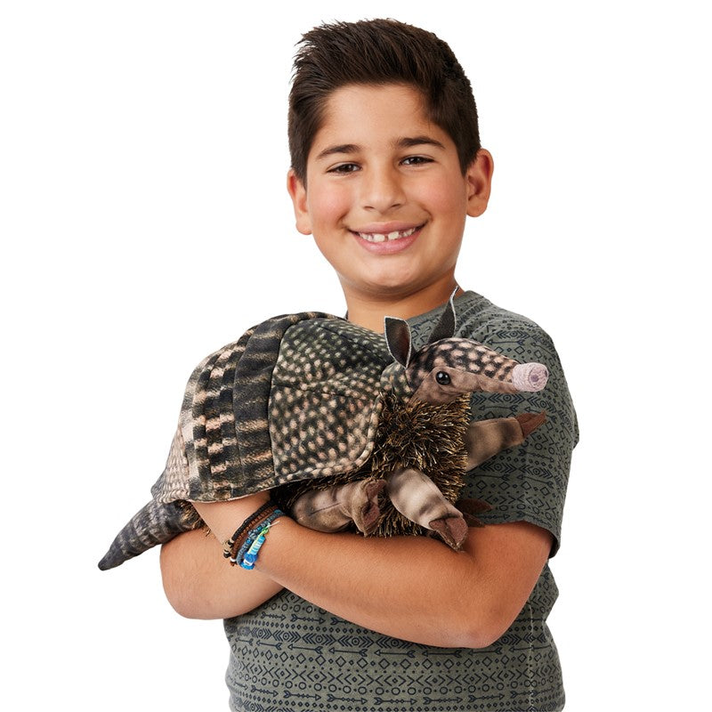 Boy smiling and holding a detailed Armadillo Puppet with patterned fabric and fuzzy belly, 17 inches long.