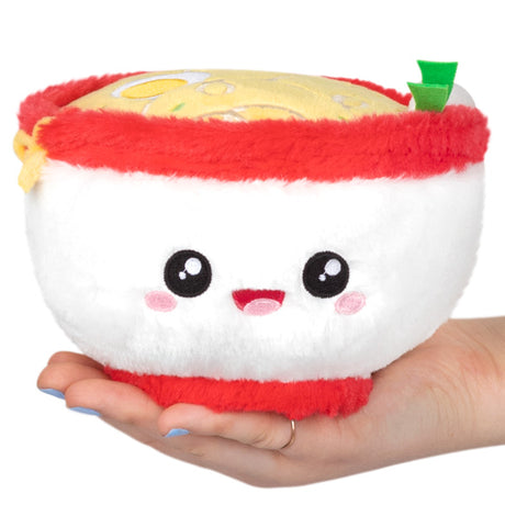 Ramen Snackers plush toy bowl with smiling face and noodle details held in hand, soft polyester fiber plush.